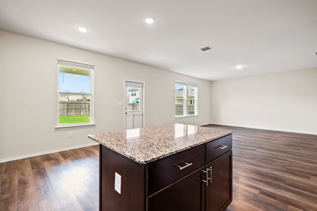 128 Rock Nettle, New Braunfels, TX 78130 - kitchen featuring dark wood-style floors, dark brown cabinetry, light stone countertops, recessed lighting, and a kitchen island