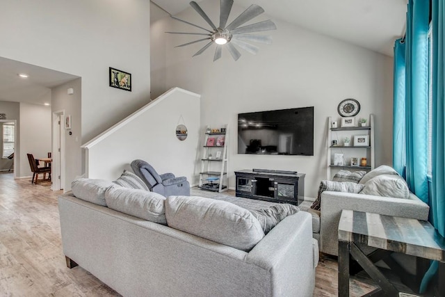17101 Borromeo Ave, Pflugerville, TX 78660 - living area featuring light wood-type flooring, a ceiling fan, high vaulted ceiling, stairway, and baseboards