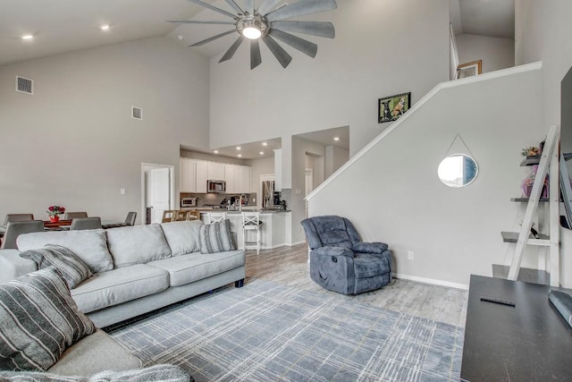 17101 Borromeo Ave, Pflugerville, TX 78660 - living area with high vaulted ceiling, ceiling fan, light wood-style flooring, and baseboards