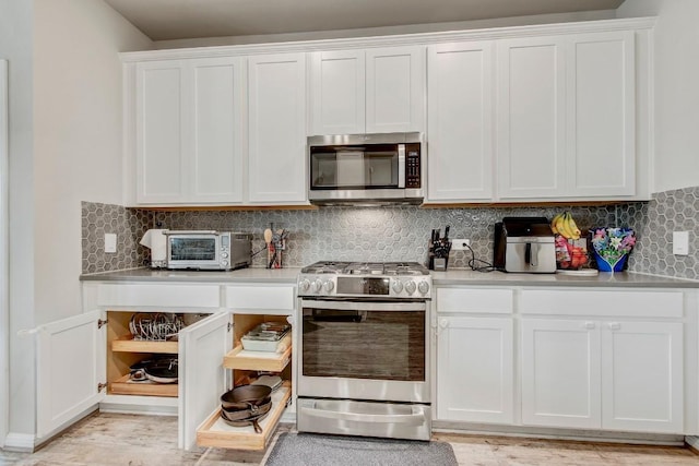 17101 Borromeo Ave, Pflugerville, TX 78660 - kitchen with appliances with stainless steel finishes, white cabinetry, light countertops, and tasteful backsplash