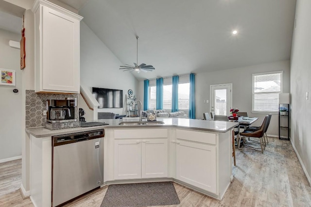 17101 Borromeo Ave, Pflugerville, TX 78660 - kitchen with dishwasher, a sink, lofted ceiling, light countertops, and white cabinets