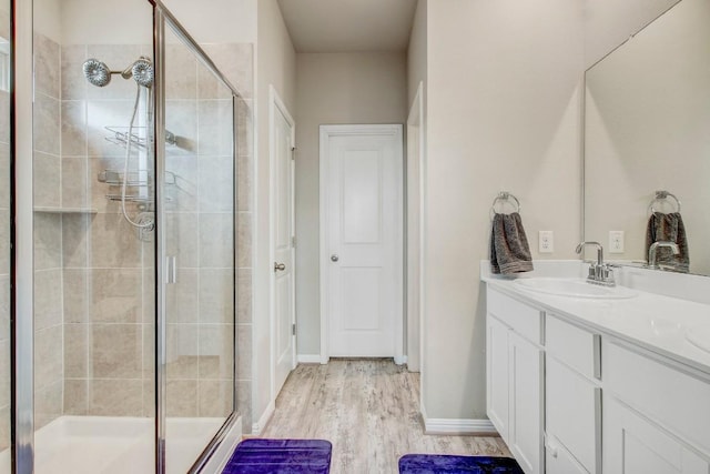 17101 Borromeo Ave, Pflugerville, TX 78660 - bathroom with a shower stall, vanity, wood finished floors, and baseboards