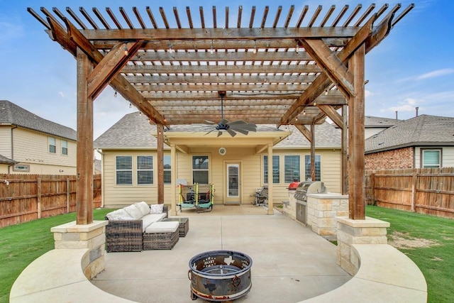 17101 Borromeo Ave, Pflugerville, TX 78660 - fenced backyard featuring a patio, an outdoor kitchen, a ceiling fan, an outdoor living space with a fire pit, and a pergola