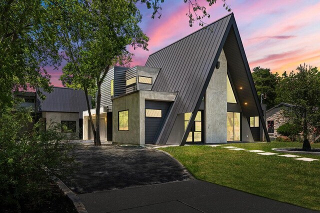 4506 Clawson Rd Unit 1, Austin, TX 78745 - view of front facade with driveway, a garage, a lawn, metal roof, and stucco siding
