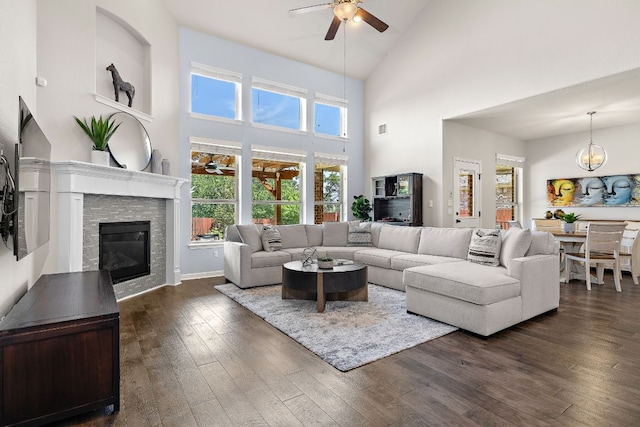2313 Legend Hill Dr, Leander, TX 78641 - living area with a ceiling fan, high vaulted ceiling, dark wood finished floors, a stone fireplace, and a chandelier