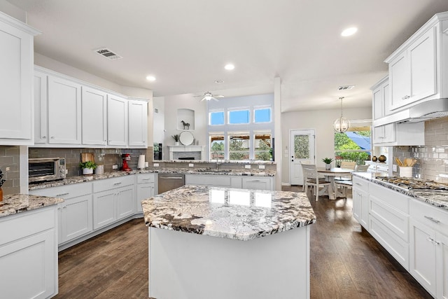 2313 Legend Hill Dr, Leander, TX 78641 - kitchen featuring stainless steel appliances, tasteful backsplash, a center island, a ceiling fan, and dark wood-style flooring