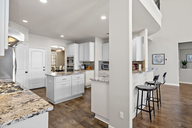 2313 Legend Hill Dr, Leander, TX 78641 - kitchen featuring range hood, backsplash, white cabinets, and recessed lighting