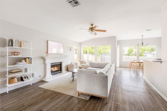 8908 Campo Verde Ct, Austin, TX 78749 - living area featuring wood finished floors, a warm lit fireplace, a ceiling fan, baseboards, and vaulted ceiling