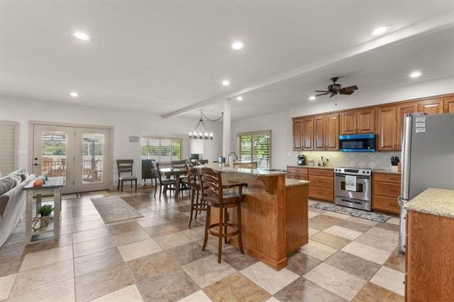 1002 Scenic Loop, Kingsland, TX 78639 - kitchen with appliances with stainless steel finishes, brown cabinets, recessed lighting, backsplash, and a breakfast bar area