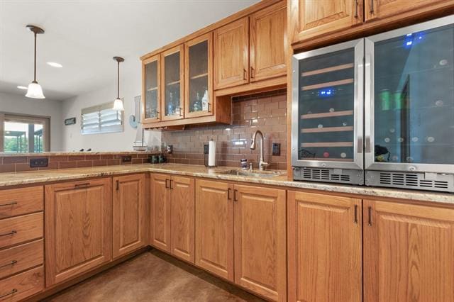 1002 Scenic Loop, Kingsland, TX 78639 - kitchen featuring a sink, beverage cooler, decorative backsplash, hanging light fixtures, and glass insert cabinets