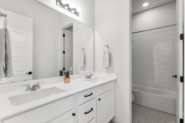 8904 Apogee Blvd, Austin, TX 78744 - full bathroom with double vanity, toilet, washtub / shower combination, and recessed lighting