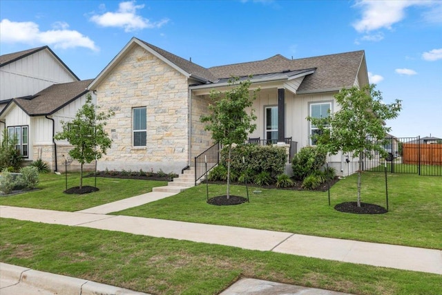 8904 Apogee Blvd, Austin, TX 78744 - view of front facade with board and batten siding, stone siding, a shingled roof, and a porch