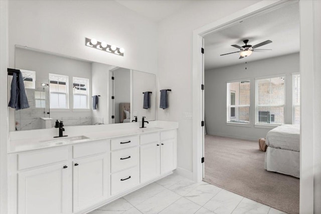 8904 Apogee Blvd, Austin, TX 78744 - full bathroom featuring double vanity, ensuite bathroom, ceiling fan, marble look tiles, and healthy amount of natural light