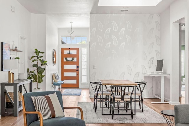 3712 Sawmill Dr, Austin, TX 78749 - dining room with wallpapered walls, wood finished floors, an accent wall, and baseboards