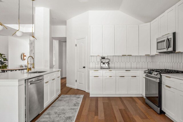 3712 Sawmill Dr, Austin, TX 78749 - kitchen featuring appliances with stainless steel finishes, a sink, light countertops, tasteful backsplash, and vaulted ceiling