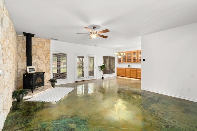 400 S Sledge St, Kyle, TX 78640 - unfurnished living room featuring a wood stove, ceiling fan, and a chandelier