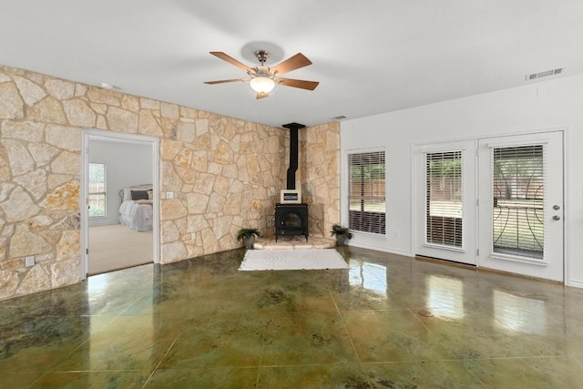 400 S Sledge St, Kyle, TX 78640 - unfurnished living room with a wood stove, plenty of natural light, and ceiling fan
