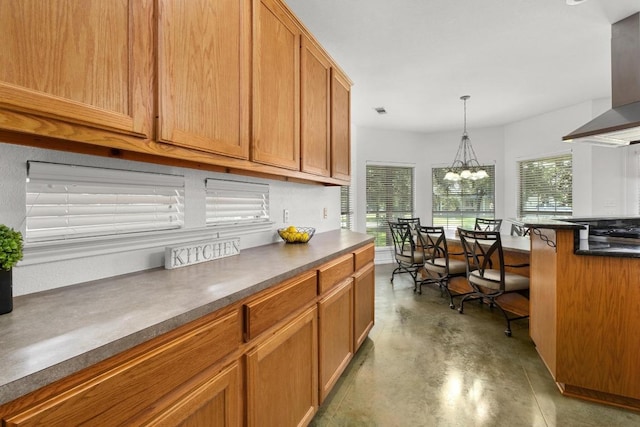 400 S Sledge St, Kyle, TX 78640 - kitchen featuring dark countertops, wall chimney exhaust hood, finished concrete floors, hanging light fixtures, and brown cabinets