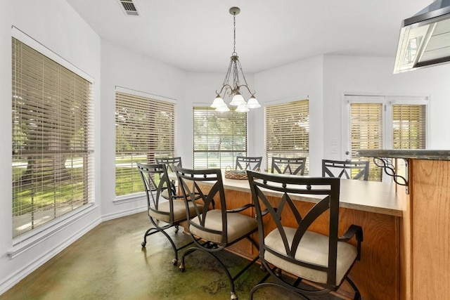 400 S Sledge St, Kyle, TX 78640 - dining space with finished concrete floors, a chandelier, plenty of natural light, and baseboards