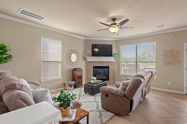 3517 Shellcastle Ln, Round Rock, TX 78681 - living room with crown molding, a tiled fireplace, ceiling fan, and light tile patterned flooring