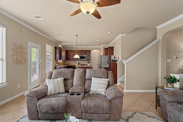 3517 Shellcastle Ln, Round Rock, TX 78681 - living area featuring arched walkways, light tile patterned floors, ceiling fan, stairway, and ornamental molding