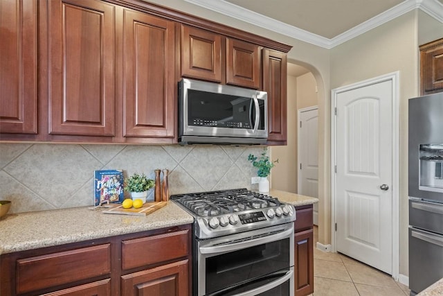 3517 Shellcastle Ln, Round Rock, TX 78681 - kitchen featuring stainless steel appliances, crown molding, arched walkways, light tile patterned floors, and tasteful backsplash