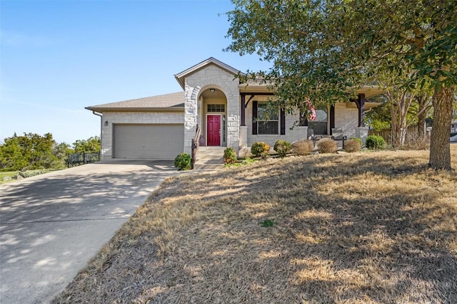 5501 Wild Foxglove Rd, Spicewood, TX 78669 - view of front of property with stone siding, a garage, and concrete driveway