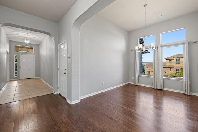 5501 Wild Foxglove Rd, Spicewood, TX 78669 - entrance foyer with a chandelier, arched walkways, hardwood / wood-style floors, and baseboards