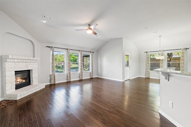5501 Wild Foxglove Rd, Spicewood, TX 78669 - unfurnished living room with ceiling fan, lofted ceiling, healthy amount of natural light, a glass covered fireplace, and dark wood-type flooring