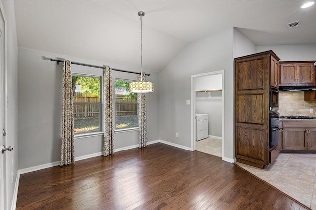 5501 Wild Foxglove Rd, Spicewood, TX 78669 - unfurnished dining area featuring washer / dryer, vaulted ceiling, light wood-type flooring, and baseboards