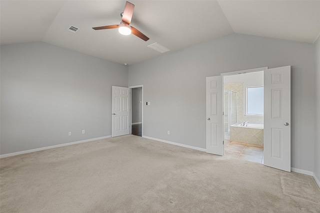 5501 Wild Foxglove Rd, Spicewood, TX 78669 - unfurnished bedroom with lofted ceiling, light colored carpet, baseboards, connected bathroom, and a ceiling fan