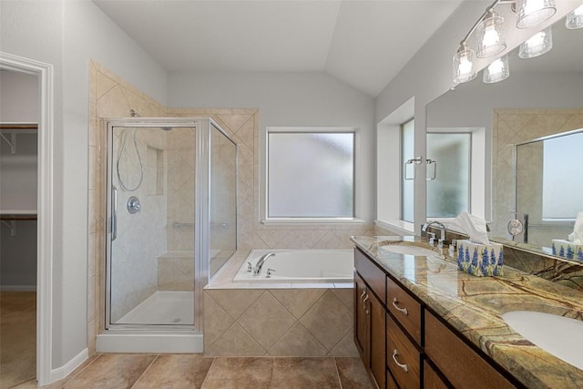5501 Wild Foxglove Rd, Spicewood, TX 78669 - bathroom with a shower stall, double vanity, a walk in closet, a garden tub, and vaulted ceiling