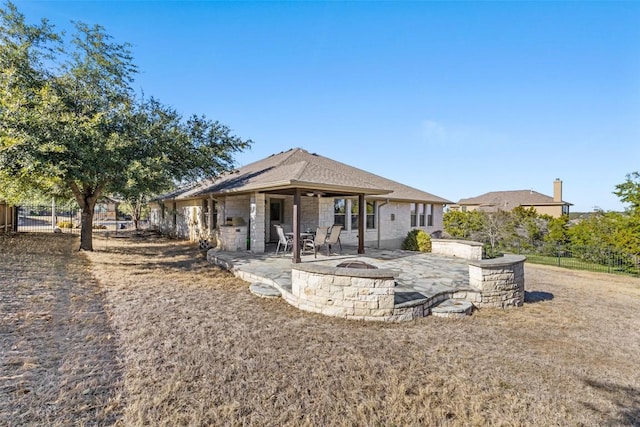 5501 Wild Foxglove Rd, Spicewood, TX 78669 - rear view of house featuring a fire pit, a patio, and stone siding