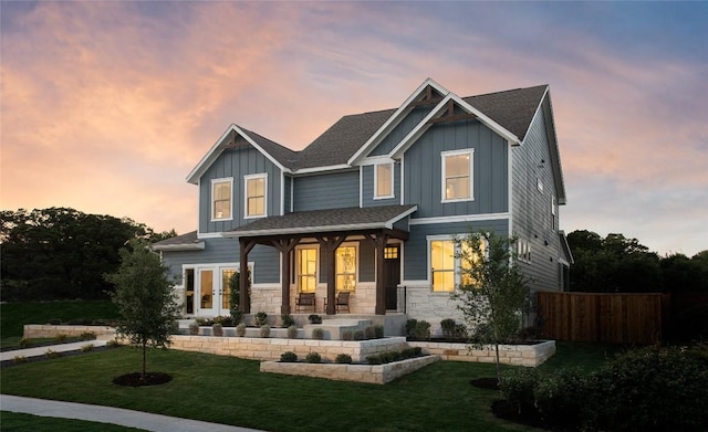 225 Hazy Hills Loop, Dripping Springs, TX 78620 - view of front facade featuring board and batten siding, covered porch, french doors, and stone siding