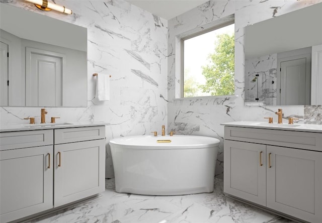 225 Hazy Hills Loop, Dripping Springs, TX 78620 - full bath with two vanities, a freestanding tub, marble finish floors, and stone wall