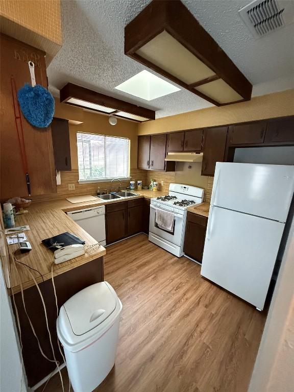 10502 Golden Meadow Dr, Austin, TX 78758 - kitchen featuring white appliances, a sink, under cabinet range hood, light countertops, and a textured ceiling