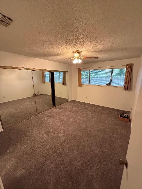 10502 Golden Meadow Dr, Austin, TX 78758 - unfurnished bedroom featuring carpet, a textured ceiling, a ceiling fan, and a closet