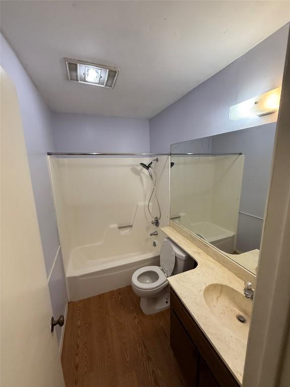 10502 Golden Meadow Dr, Austin, TX 78758 - bathroom featuring wood finished floors, shower / bath combination, toilet, and vanity
