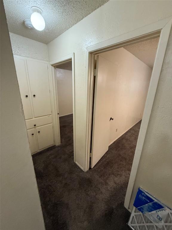 10502 Golden Meadow Dr, Austin, TX 78758 - hall featuring a textured ceiling, dark carpet, and a textured wall