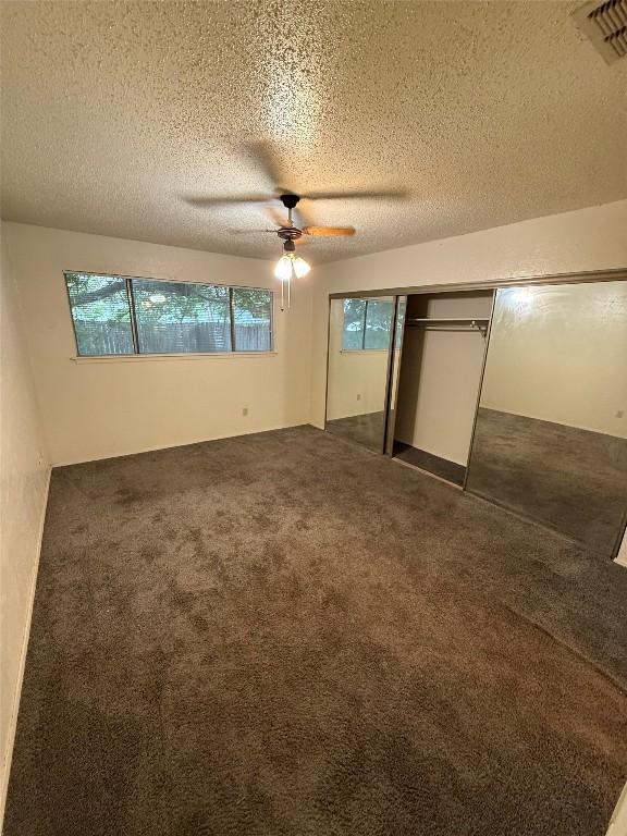10502 Golden Meadow Dr, Austin, TX 78758 - unfurnished bedroom with carpet floors, a textured ceiling, a closet, and a ceiling fan