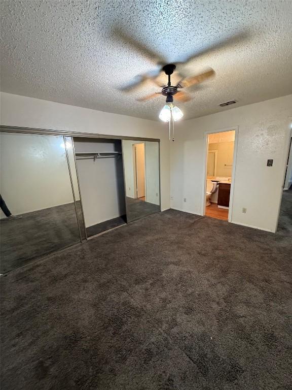 10502 Golden Meadow Dr, Austin, TX 78758 - unfurnished bedroom featuring a closet, a textured ceiling, dark colored carpet, and ceiling fan