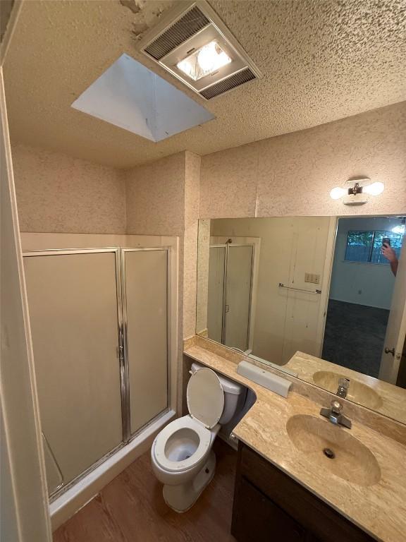 10502 Golden Meadow Dr, Austin, TX 78758 - full bath with toilet, a stall shower, vanity, and wood finished floors
