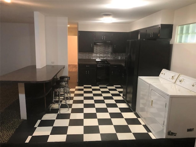 2403 Sherwood Ln, Austin, TX 78704 - kitchen with light flooring, separate washer and dryer, black gas range oven, and dark cabinets