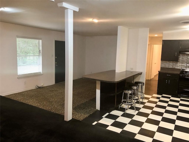 2403 Sherwood Ln, Austin, TX 78704 - kitchen featuring black stove, tile patterned floors, dark countertops, and dark cabinets