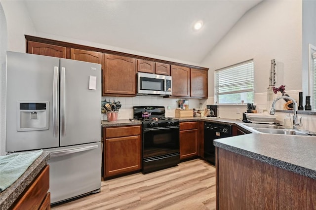 8505 Shallot Way, Austin, TX 78748 - kitchen with black appliances, a sink, vaulted ceiling, tasteful backsplash, and light wood-style floors