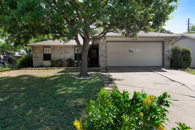 5808 Spring Meadow Rd, Austin, TX 78744 - view of front of home with an attached garage, driveway, a front lawn, and brick siding