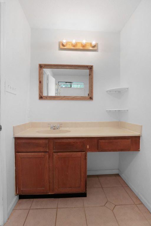 5808 Spring Meadow Rd, Austin, TX 78744 - bathroom with vanity, tile patterned floors, and baseboards