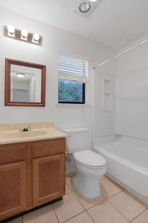 5808 Spring Meadow Rd, Austin, TX 78744 - bathroom with toilet, vanity, bathtub / shower combination, a textured ceiling, and tile patterned flooring