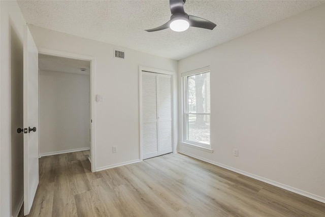 8600 Fathom Cir Unit 1303, Austin, TX 78750 - unfurnished bedroom with light wood-type flooring, a textured ceiling, a closet, and ceiling fan