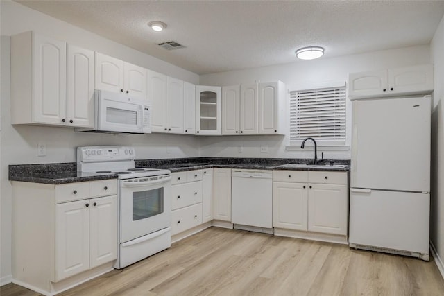 8600 Fathom Cir Unit 1303, Austin, TX 78750 - kitchen with white appliances, a sink, white cabinetry, light wood-style floors, and glass insert cabinets